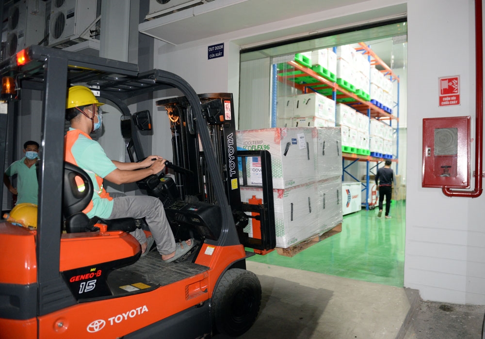 Các phương tiện tại kho lạnh tiếp nhận từng kiện vaccine.